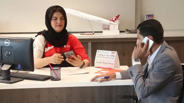 عاملة حجوزات سفر تستقبل مسافراً