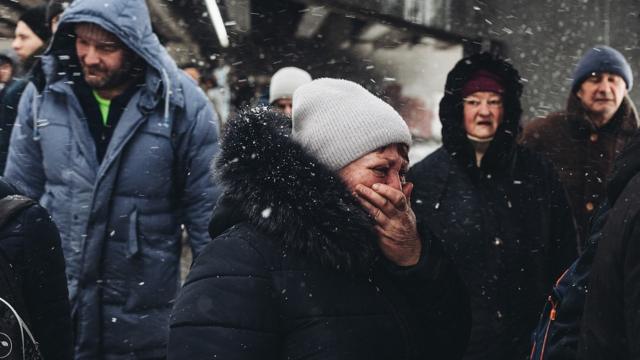 Mujer se agarra el rostro mientras llora tras despedirse de su esposo antes huir a un país vecino