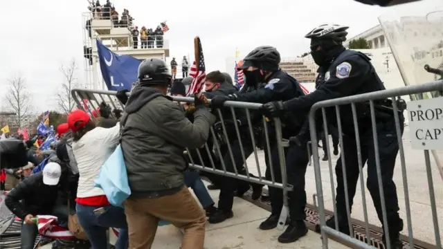 Manifestantes e policiais seguram cercaprognosticos futebol paulo rebeloárea externa do Capitólio