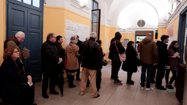 Ciudadanos hacen cola para votar en un colegio electoral de Roma.