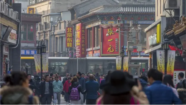 Imagem mostra pessoas caminhandobanca alta blazecentro comercialbanca alta blazePequim, na China