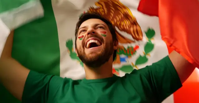 Mexicano con bandera celebrando.