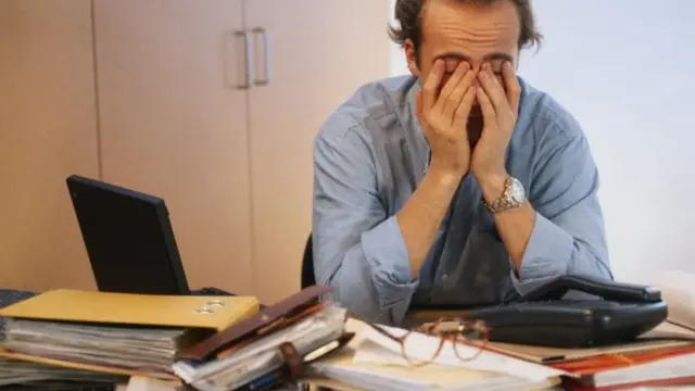 موظف يضع يديه على وجهه