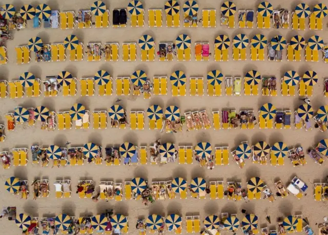 ร่มและเก้าอี้ที่จัดวางอย่างเป็นระเบียบ ที่ชายหาดพลายา เด อมาโดเรส บนเกาะแกรนด์คานาเรีย