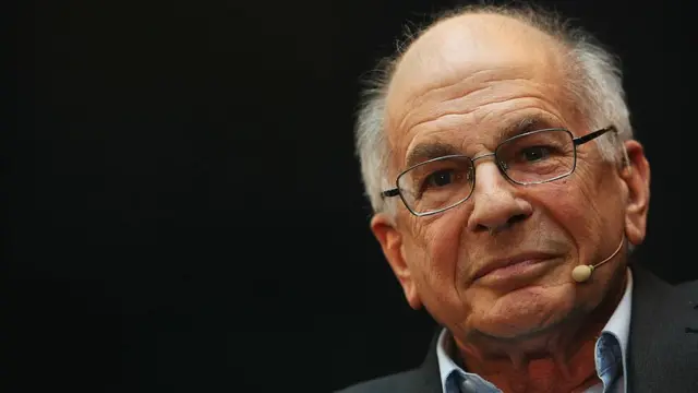 Daniel Kahneman com microfoneaplicativo da blaze apostarosto sorrindo timidamente, e fotografado do ombro para cima, aparentementeaplicativo da blaze apostauma palestra