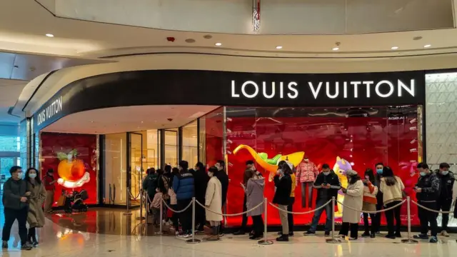 Des acheteurs chinois font la queue devant un magasin de luxe