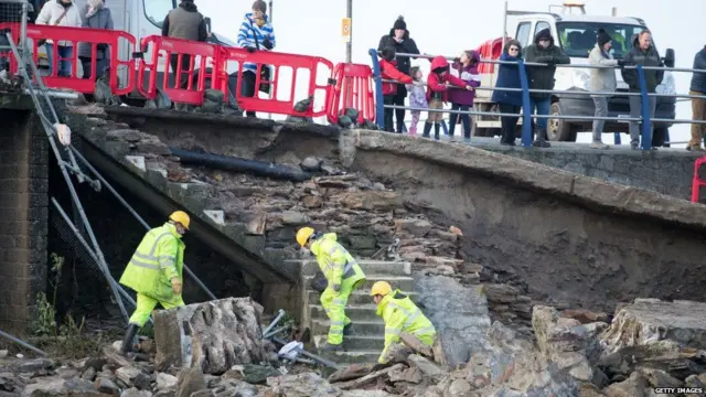 બ્રિટનના પોર્ટ્રેટ વિસ્તારમાં પુલ ભાંગવાથી દિવાલની મરામત કરતા કર્મચારીઓની તસવીર