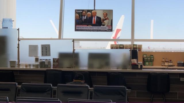 约翰肯尼迪机场的电视屏上，美国总统特朗普正在发表讲话。