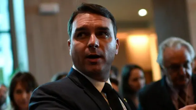 Flavio Bolsonaro apareceroleta europeia grátiscorredor com outras pessoas e apontando para o lado