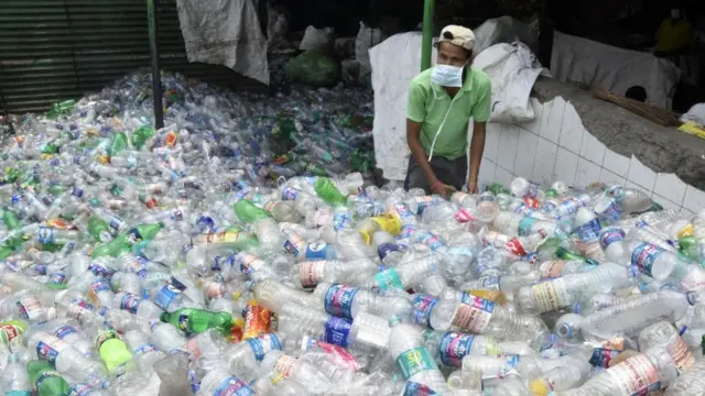 plastik şişe toplayan bir Hintli.