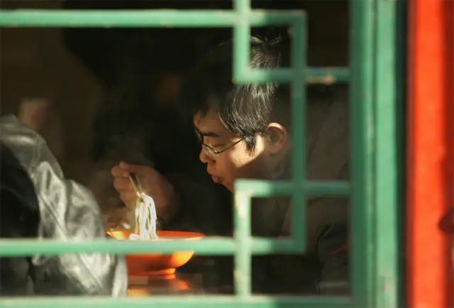 Hombre comiendo noodles