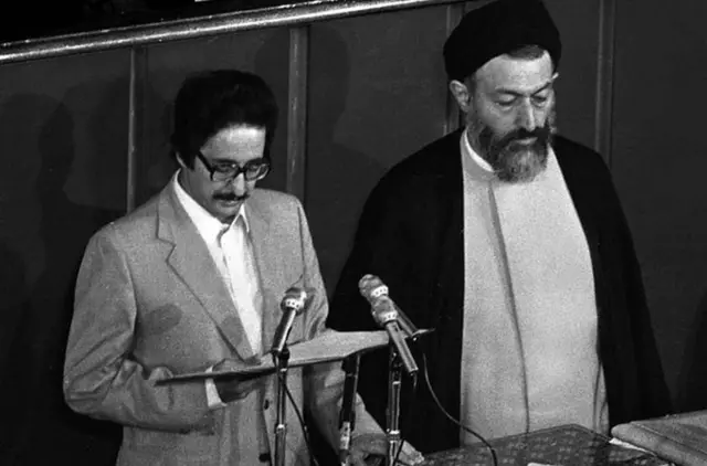 مراسم سوگند ریاست جمهوری ابوالحسن بنی‌صدر. محمد بهشتی، رئیس وقت دیوان عالی کشور (عالی‌ترین مقام قضایی در آن زمان) در کنار آقای بنی‌صدر ایستاده است