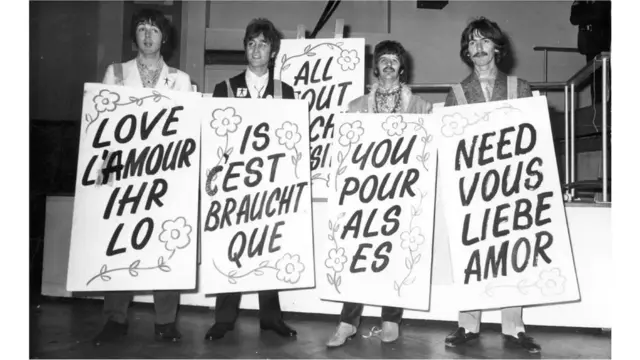 4 hommes tenant chacun une pancarte.