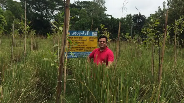 বিন্না ঘাসের সাথে গবেষক মোহাম্মদ শরীফুল ইসলাম