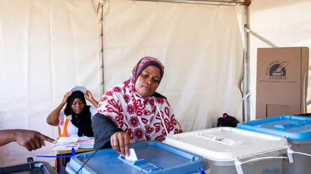 Une Femme votant dans un bureau de vote à Zanzibar
