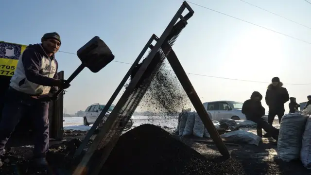 Мужчина продает уголь