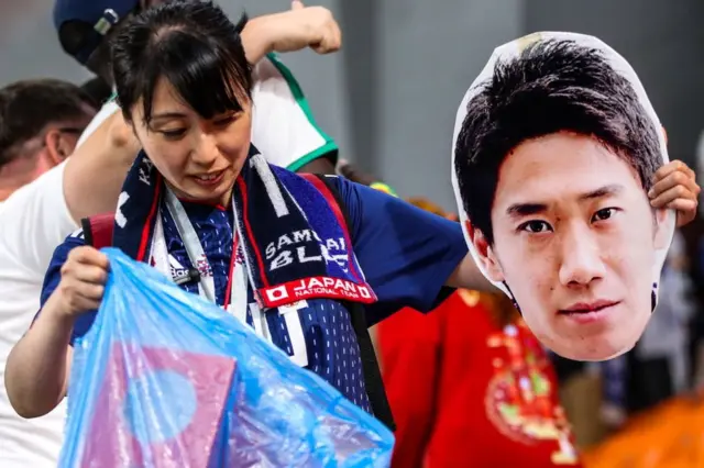 Aficionada japonesa de fútbol recoge basura de un estadio tras un partido entre Japón y Senegal durante el Mundial de Rusia el 24 de junio de 2018.