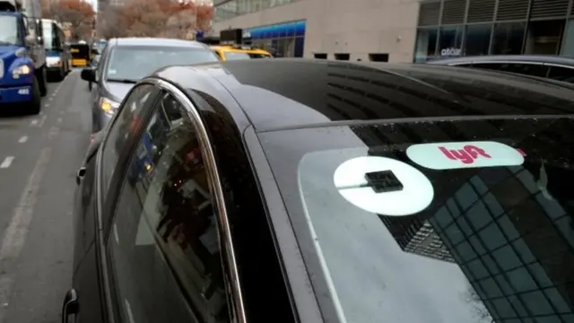 Un auto con logos de Uber y Lyft