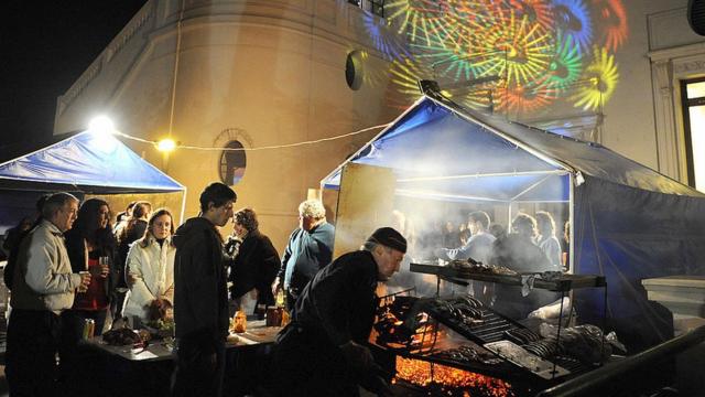 Gente haciendo fila para comer carne en la Noche de la Nostalgia en Maroñas.