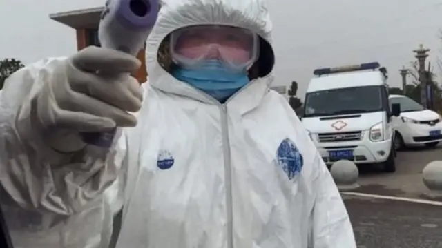 Petugas memeriksa wartawan BBC yang memasuki perbatasan Wuhan.