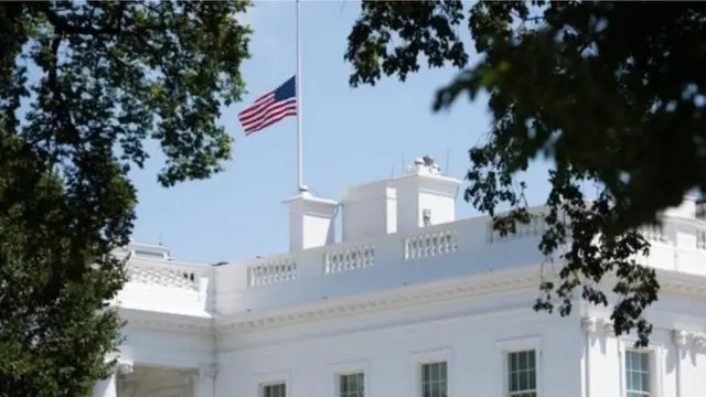 ኣብ ቤት-ጽሕፈት ፕረዚደንት ኣመሪካ ባንዴራታት ኣብ ፍርቂ-ሰንደቕ ተሰቒሎም ውዒሎም