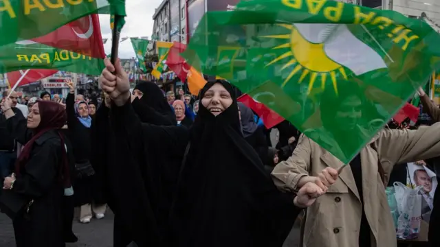 Supporters of Turkey's President Recep Tayyip Erdogan wave national, AK Party and Huda Par flags