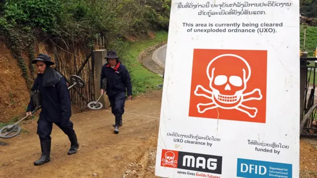 рабочие с миноискателями в Лаосе