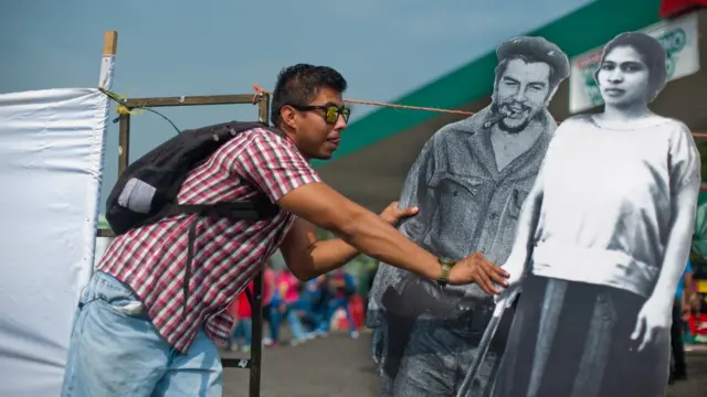 Un joven sostiene imágenes de Prudencia Ayala junto a la de Ernesto 'Che' Guevara.