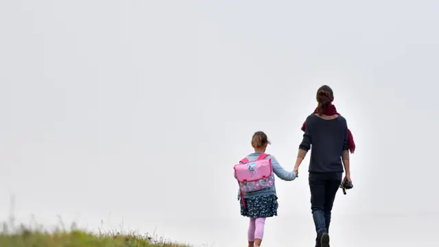 Женщина держит ребенка за руку