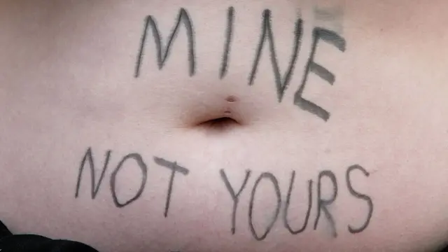 Estómago de esta chica con escrito que dice: "Mío, no tuyo".