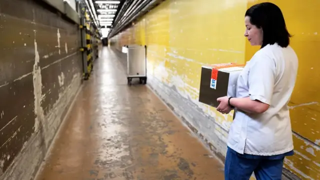 Una investigadora en un pasillo con paredes descascaradas del Instituto Eliava.