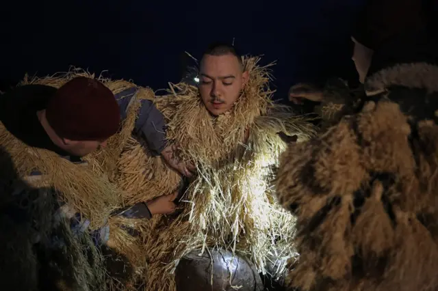 Survakarski kostimi mogu da budu veoma teški, naročito ako nosite više velikih zvona, pa je prilikom oblačenja neophodna pomoć drugih učesnika.