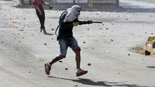 Un manifestante con la cara cubierta