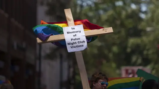 Una cruz con la bandera gay y la inscripción: "En memoria de las víctimas del club nocturno Pulse".