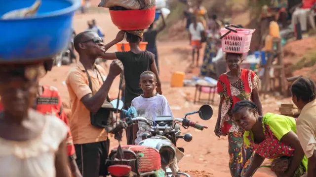 Vendedores y otros ciudadanos caminan en una calle del barrio 3Z, donde las confrontaciones entre la milicia de Kamuina Nsapu y el ejército son frecuentes en Tshikapa.