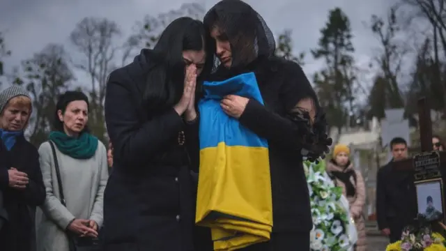 Femmes pleurant dans un cimetière à Lviv, mars 2024