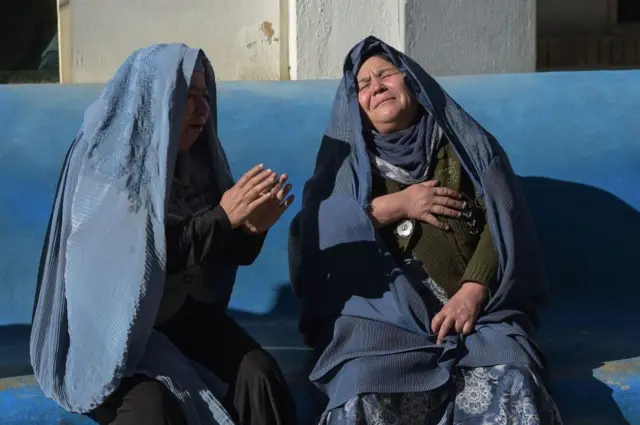 Two Afghan women weep for their relatives at a hospital following explosions at a cultural centre in Kabul in 2017