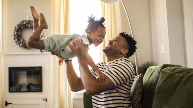 Un padre y su hija juegan y ríen