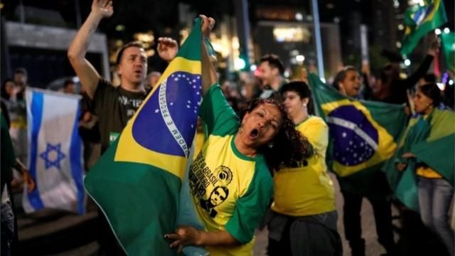 Supporters of Jair Bolsonaro, far-right lawmaker and presidential candidate of the Social Liberal Party (PSL), react after polls closed,