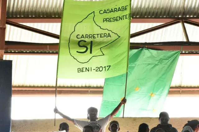 Joven con un cartel a favor de la carretera