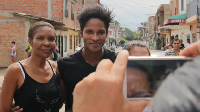 Una admiradora se toma una foto con Fernando Montaño en el barrio de Cali en el que creció el bailarín.