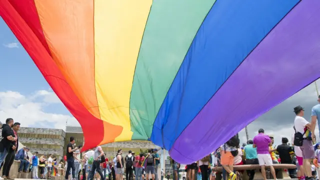 Manifestantes bajo una bandera del orgullo gay fuera de la Corte Suprema de Costa Rica.