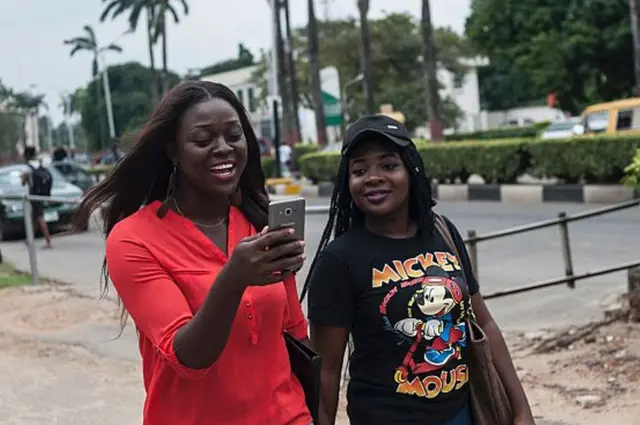 Ụmụnwaanyị na-ele ekwentị ha na amụ amụ