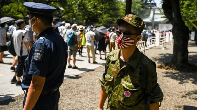 Un homme portant un masque de protection avec le drapeau du Soleil Levant à Tokyo en août 2020.
