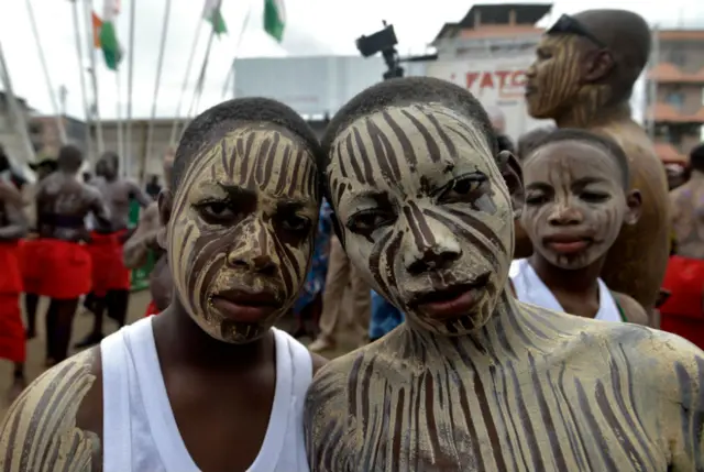 Two adolescent boys pose together, wearing matching facepaint.