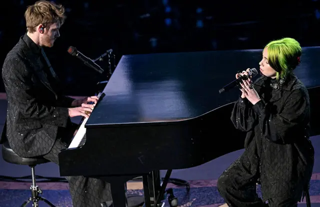 Finneas O'Connell y Billie Eilish cantando en el escenario