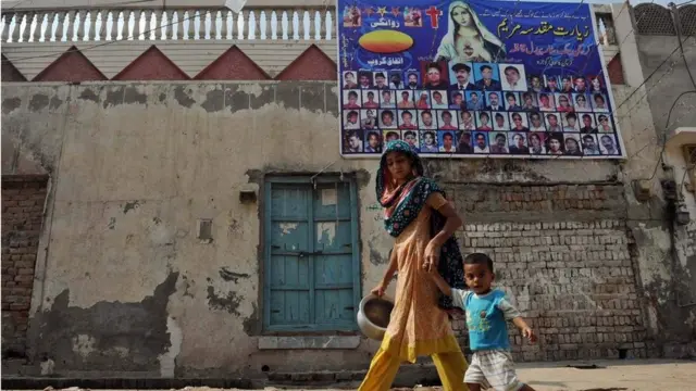 பஞ்சாப்பில் கோஜ்ரா நகரில் குழந்தையுடன் செல்லும் பெண்