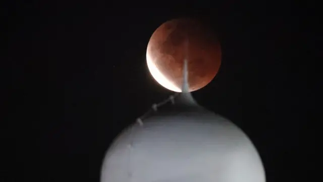 Lunar eclipse is observed over dome of Al Azhar Mosque in Jakarta, Indonesia, 26 May 2021. Total Lunar Eclipse of Blood Moon on 26 May 2021