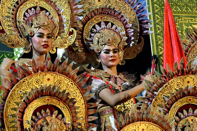 Balinese woman pose before they perform a traditional to release the sun of 2025, and to welcome the sun of 2026, during a New Year's Eve celebration in Denpasar, on Indonesia's resort island of Bali on December 31, 2025.