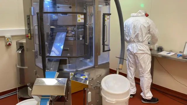 Duża tabletkarka sprasowuje proszek w formę tabletek.